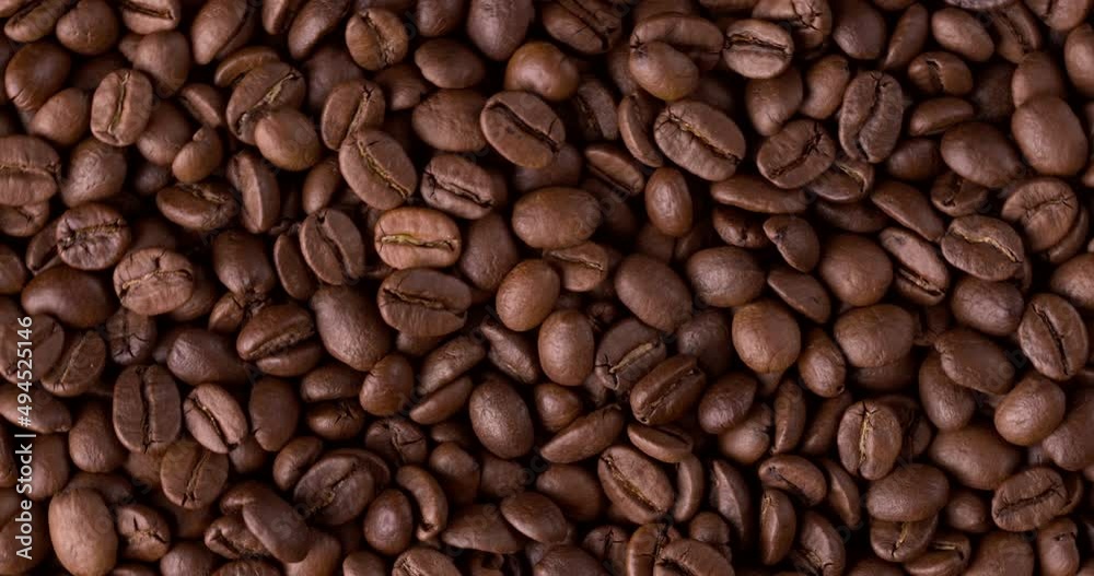 Slow motion close-up of whole roasted coffee beans. Rotation and fall сoffee beans Slow motion close-up of whole roasted coffee beans. Rotation and fall сoffee beans