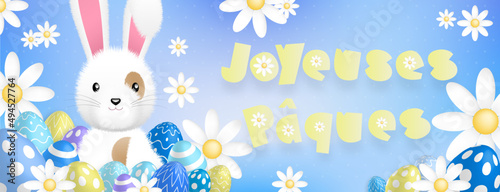 Texte jaune «Joyeuses Pâques», avec un mignon lapin blanc derriere des oeufs colorés et des fleurs sur un fond bleu