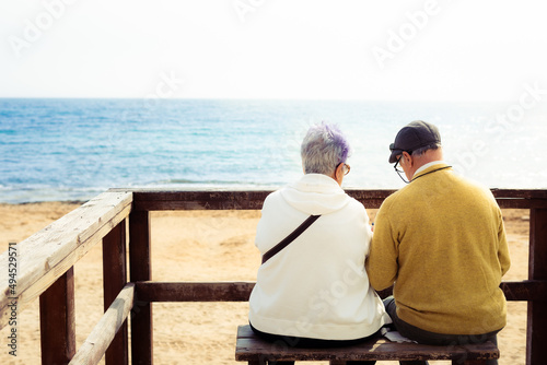 Two ancient people in front of the sea. Elderly people in Spain coast.