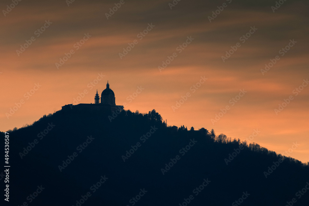 Silhouette of Superga Basilica upon a hill at sunset Italy