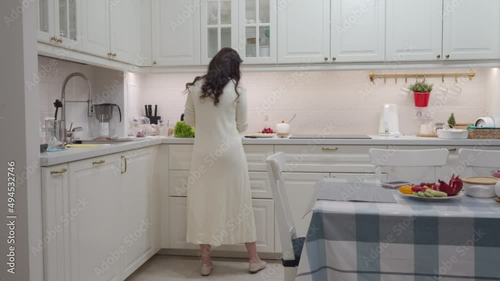 Woman setting the table for celebration dinner in the kitchen. Festive table with delicious dishes for family holiday. High quality 4k footage Woman setting the table for celebration dinner in the kitchen. Festive table with delicious dishes for family holiday. High quality 4k footage