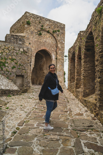 Chica joven guapa paseando y sonriendo por pueblo blando andaluz 