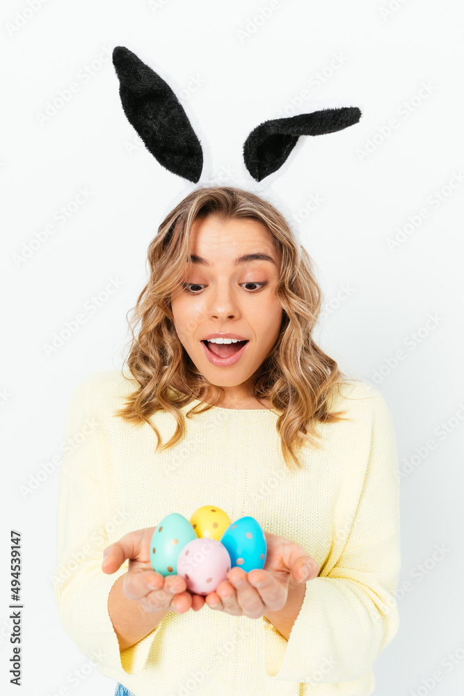 Joyful surprised young woman celebrates Easter wears bunny ears Joyful surprised young woman celebrates Easter wears bunny ears