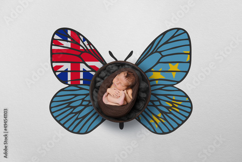 Tiny baby portrait with wings in color of national flag. Newborn photography concept. Tuvalu