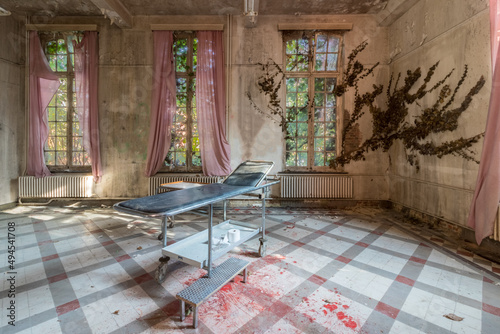 Lost Place Sanatorium. blood on the floor. Ivy grows to the window photo