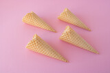 Creative photo of empty waffle cones on a pink background.
