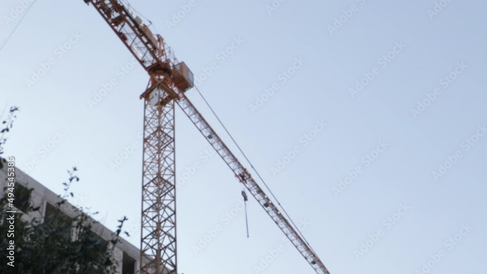 Industrial tower crane against the sky. Large construction site. The process of capital construction of a high-rise residential complex. Concrete building, construction, industrial site. Industrial tower crane against the sky. Large construction site. The process of capital construction of a high-rise residential complex. Concrete building, construction, industrial site.