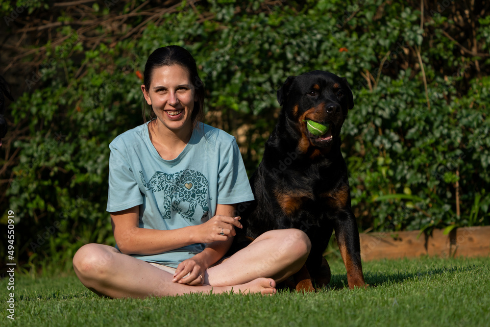 Wife Cuddling a teddy bear Rottweiler. Positive emotions showing the attachment between wife and pet love and trust and absolute endearment Wife Cuddling a teddy bear Rottweiler. Positive emotions showing the attachment between wife and pet love and trust and absolute endearment