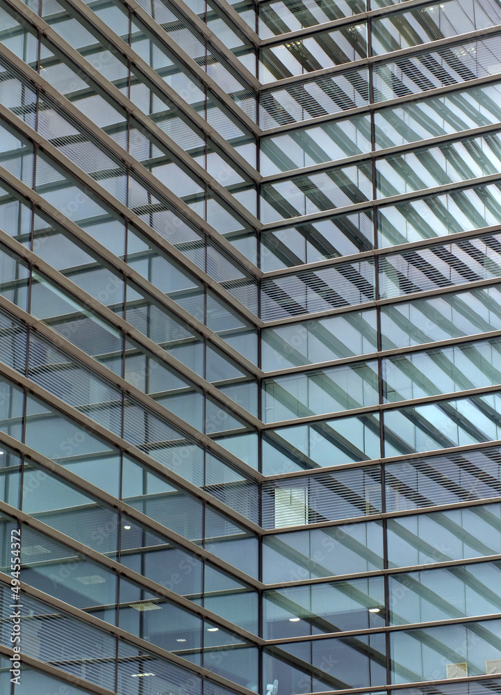 full frame modern urban office architectural abstract with geometric shapes and buildings reflected in blue glass windows full frame modern urban office architectural abstract with geometric shapes and buildings reflected in blue glass windows