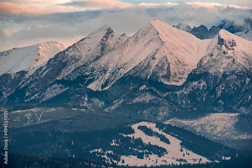 high snow-capped Tatra Mountains in the glow of the setting sun