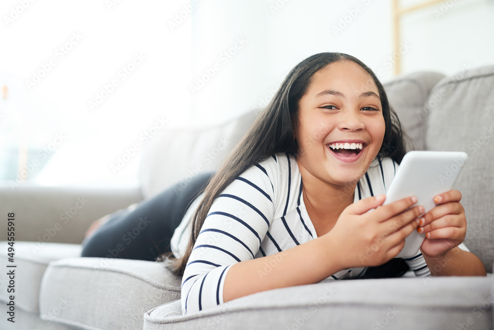 Who needs a tv when Ive got my tablet. Portrait of a happy young girl relaxing on the sofa and using a digital tablet. Who needs a tv when Ive got my tablet. Portrait of a happy young girl relaxing on the sofa and using a digital tablet.
