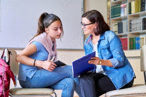 Woman school psychologist teacher talking and helping student, girl teenager