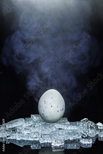Vertical shot of a Songhua egg on ice cubes against a black background photo