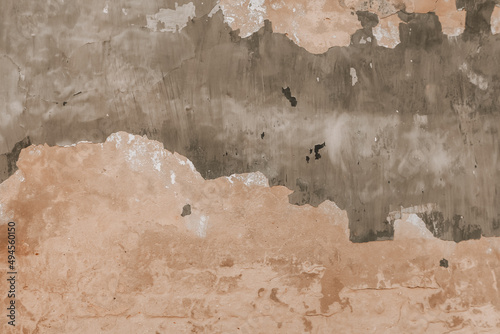 An old weathered wall with peeling paint. Concrete surface with grunge texture, abstract background.