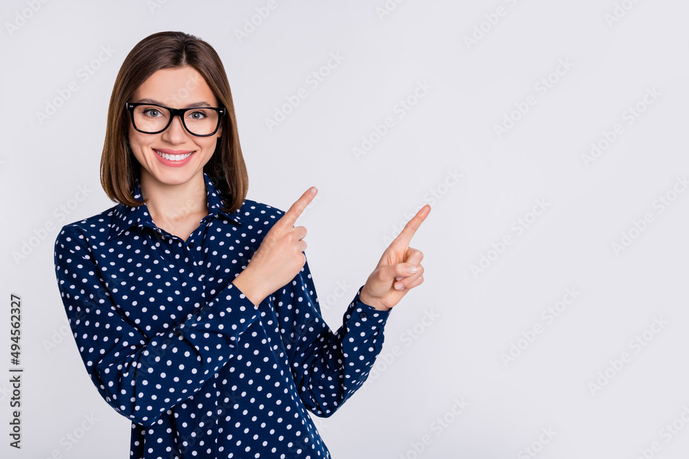 Photo of young pretty lady promoter indicate fingers empty space ads recommend suggest isolated over grey color background Photo of young pretty lady promoter indicate fingers empty space ads recommend suggest isolated over grey color background