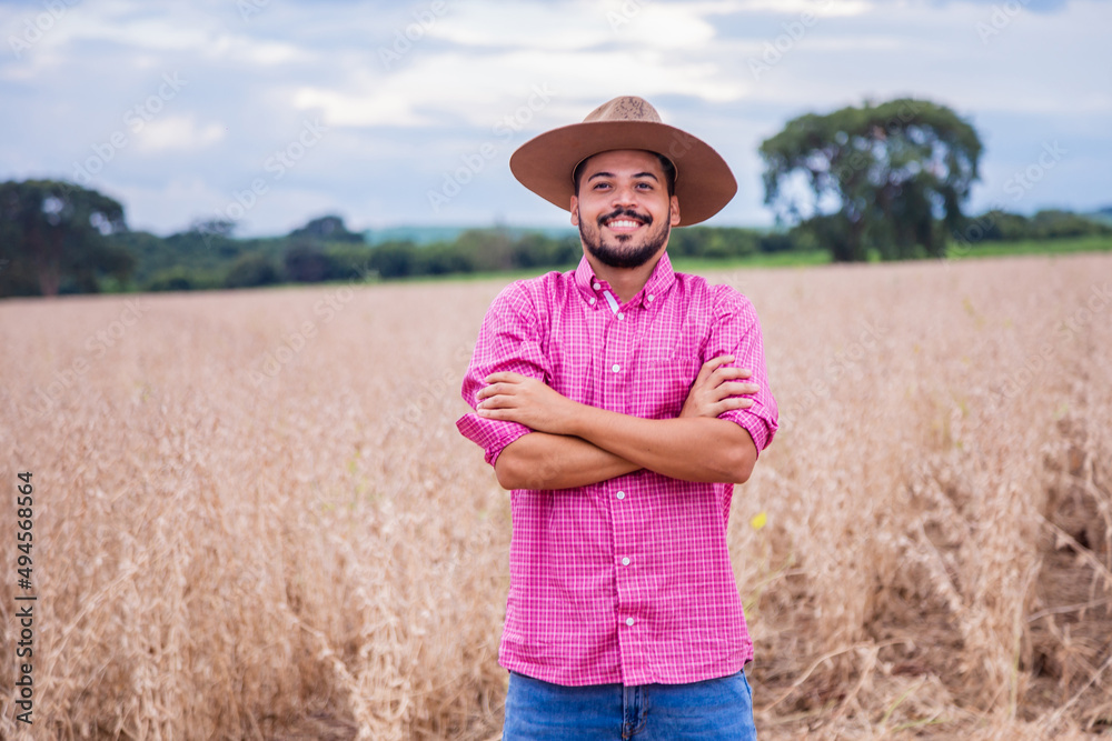 Portrait of a proud Latin American farmer standing with his arms crossed, looking at the camera.