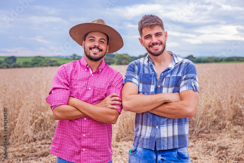 Two handsome farmer boys on the farm smiling looking at camera