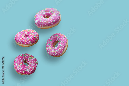 Creative food concept: levitating dounuts isolated on blue background.