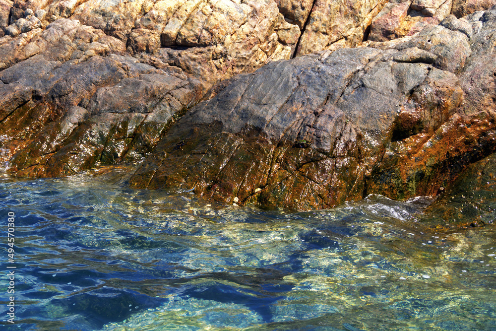 Fototapeta premium View from the water to the rocky seashore in summer. ..