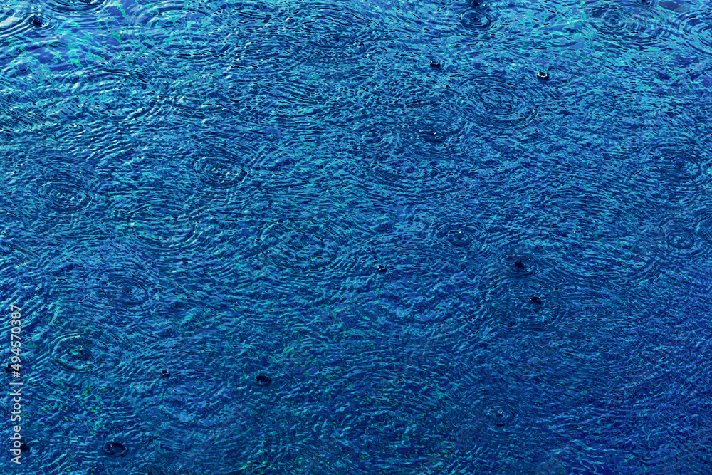 Raindrops on the surface of the pool water form circles. Raindrops on the surface of the pool water form circles.