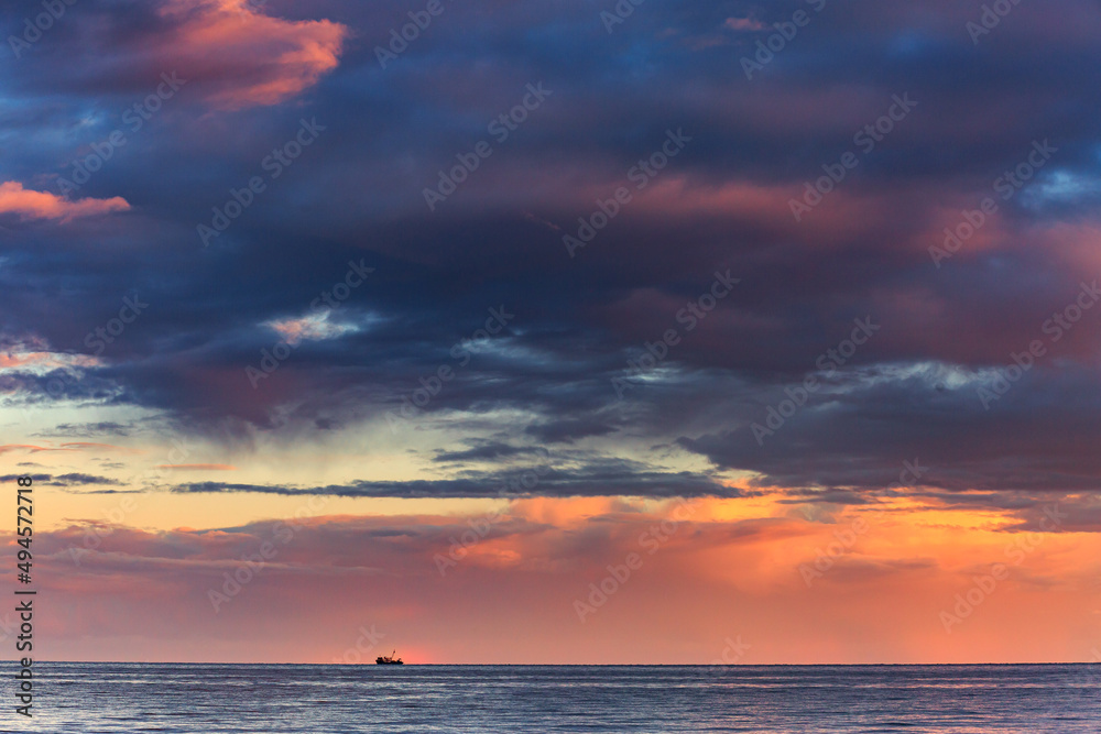 Fototapeta premium Pink sunset on the shores of the Mediterranean Sea, against the backdrop of mountains, rocky coast, summer, landscape, sea, mountains, sunset, colorful clouds, blue water.