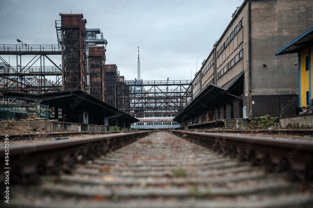 An old overgrown rail line leading into abandoned freight station in Prague