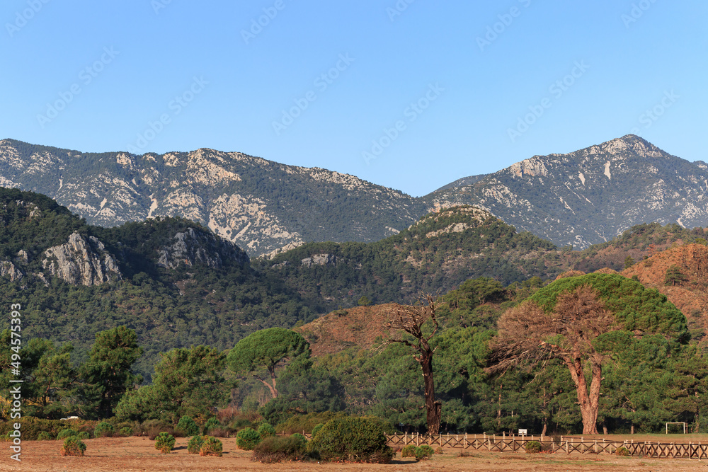 Lots of high mountains, sand, trees, blue sky and clouds, Antalya, Turkey.