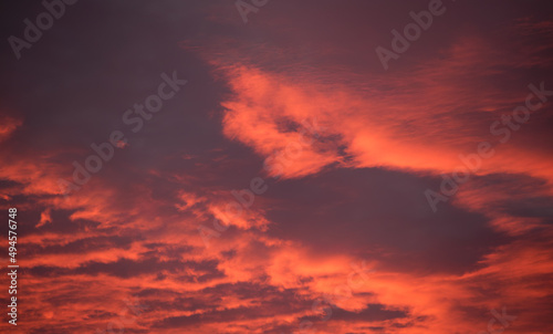Bright colorful sunset sky with vivid smooth clouds illuminated with setting sun light spreading to horizon © bilanol