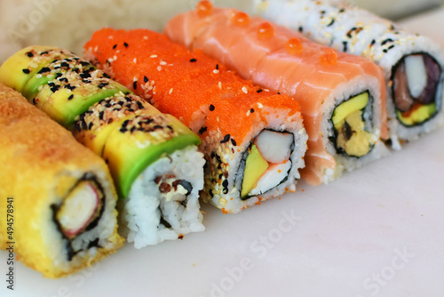 Traditional colorful suhi, cream cheese, salmon, caviar, rool sishi crunch, sesame seeds and sauce