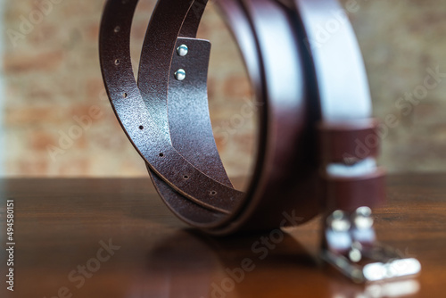 Stylish leather belt on wooden background for mens fashion