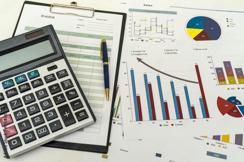 Financial paper charts with calculatop and pen on office desk Financial paper charts with calculatop and pen on office desk