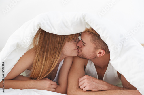 Obraz na plátně My love. Shot of an affectionate couple kissing under the covers.