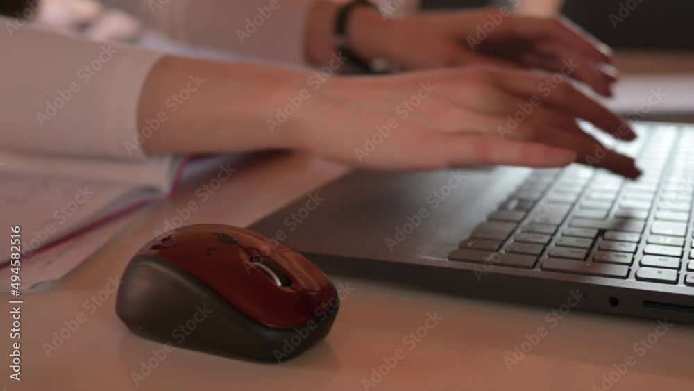 Woman using a laptop sitting at desk in office Woman using a laptop sitting at desk in office