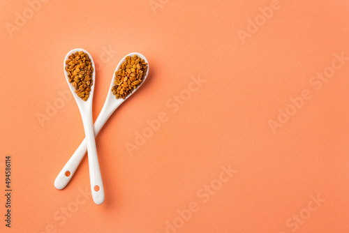 Organic fenugreek seeds in two ceramic spoons - Foenum graecum photo