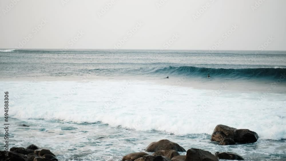 Serfers on a ocean wave on sunset, Atlantic Ocean Serfers on a ocean wave on sunset, Atlantic Ocean