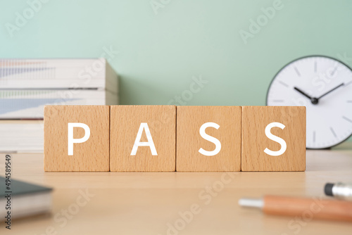 「PASS」と書かれた積み木が置かれたデスク