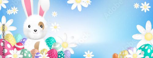a cute white rabbit behind colored eggs and flowers on a blue background