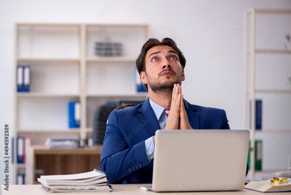 Young male employee working in the office Young male employee working in the office