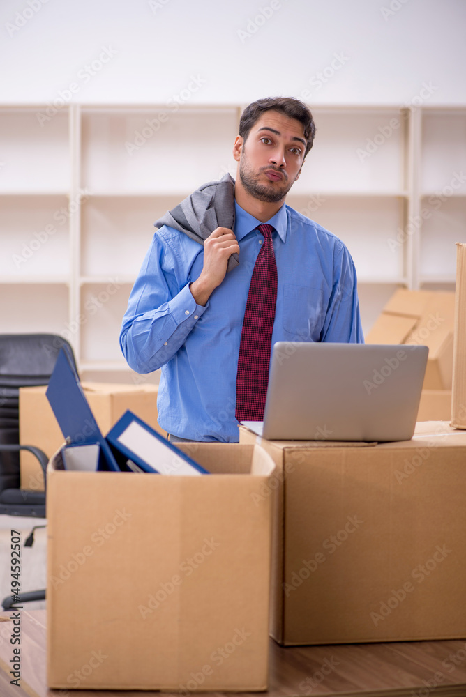 Young male employee in office relocation concept Young male employee in office relocation concept