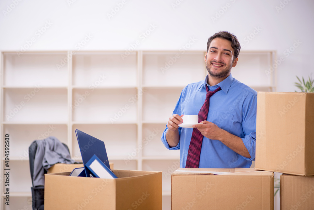 Young male employee in office relocation concept Young male employee in office relocation concept
