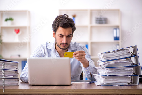 Young male employee unhappy with excessive work in the office