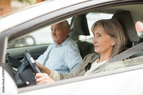 Elderly married couple driving a car in the city. Woman driving a car © JackF