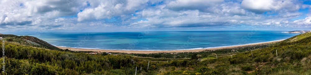 Panoramic view of the Beautiful beach of Salgados with the village of Nazare in the background, Portugal. Beautiful beach with turquoise waters in a cloudy day