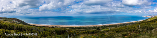 Fototapeta Naklejka Na Ścianę i Meble -  Panoramic view of the Beautiful beach of Salgados with the village of Nazare in the background, Portugal. Beautiful beach with turquoise waters in a cloudy day
