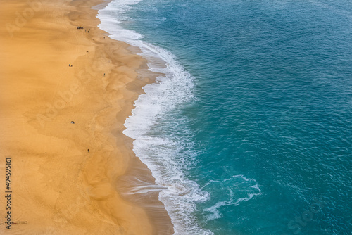 Beautiful turquoise blue waters and yellow sand at Nazaré beach - Portugal