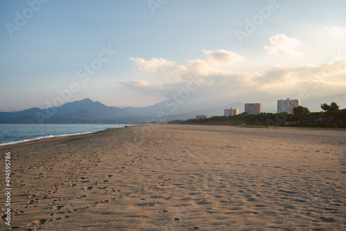 Beach on the south of France at sunset with mountains on the background