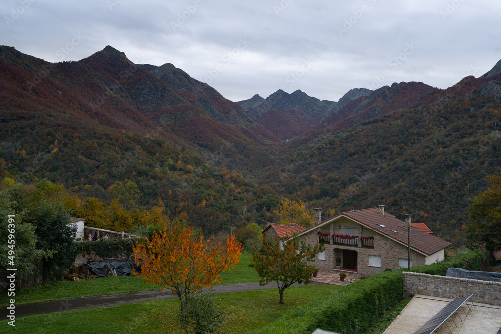 Houses in Picos de Europa nationalo park with mountains on the background during Autumn fall, in Spain