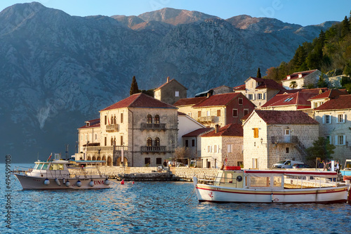 Breathtaking panoramic sunset view of the ancient city of Perast, Montenegro. Old medieval little town with red roofs and with majestic mountains on background of Adriatic sea.