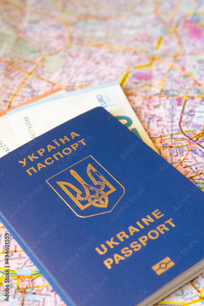 Ukrainian passport on the map of european city. Close up view. Concept of immigration and refugee Ukrainian passport on the map of european city. Close up view. Concept of immigration and refugee