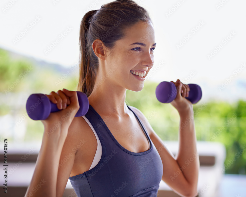 Making magic with her muscles. Shot of an attractive young woman working out with weights. Making magic with her muscles. Shot of an attractive young woman working out with weights.